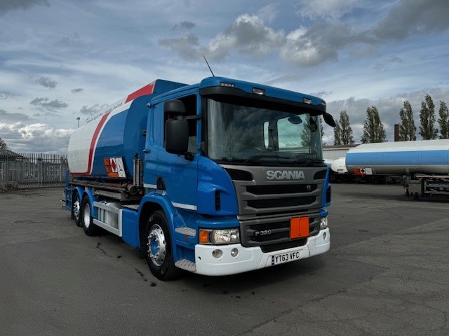 Front view of a Scania P320 fuel tanker, featuring front-mounted delivery hose and reel for efficient fuel dispensing.