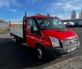 Ford Transit with flatbed, red colour in an industrial area of north east england.