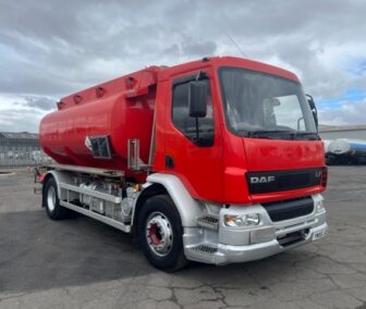 DAF tanker truck, large tank with red bodywork, white metal wheels and headlights, parked in carpark.