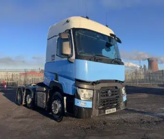 2016 Renault T480 6x2 tractor unit in blue and white, featuring 13L engine, automatic transmission, 660,276 km, MOT valid until March. Front view showing fog lamps and Renault grille, parked at industrial facility.