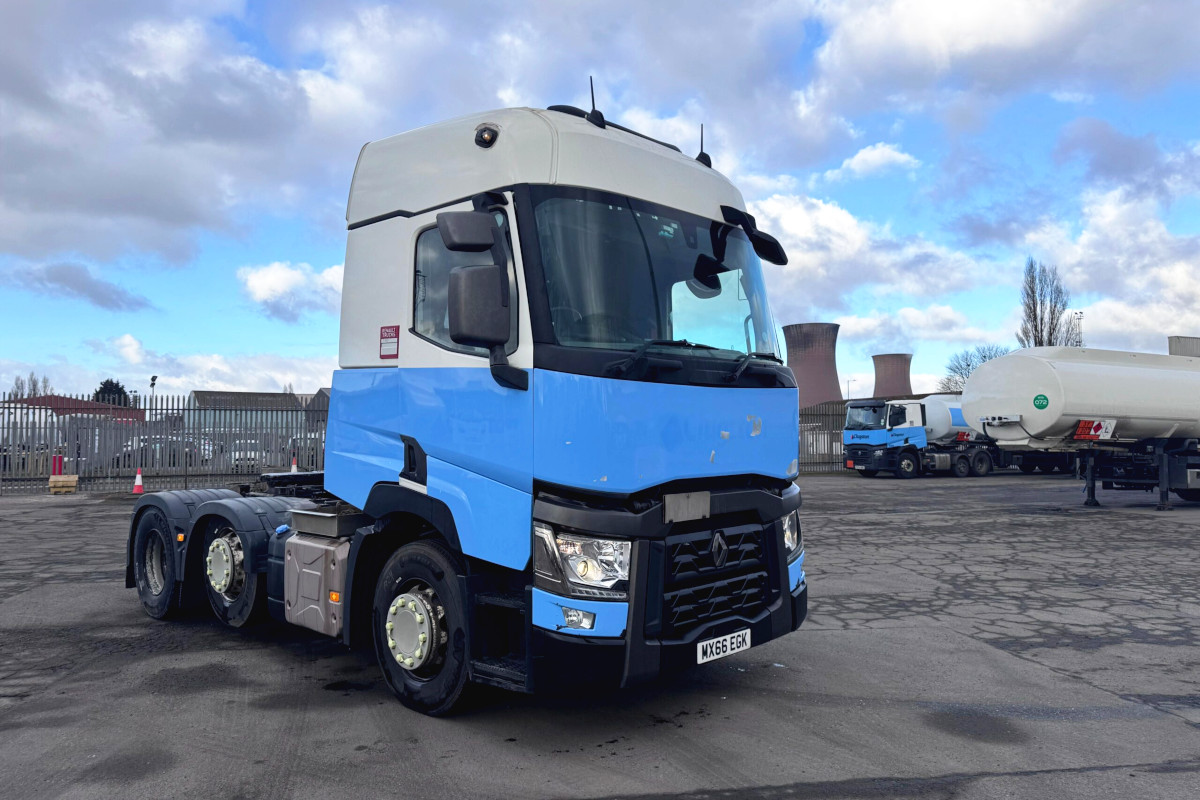 2016 Renault T480 6x2 tractor unit in blue and white livery, featuring high-roof cab and automatic gearbox, photographed at commercial vehicle depot with cooling towers in background